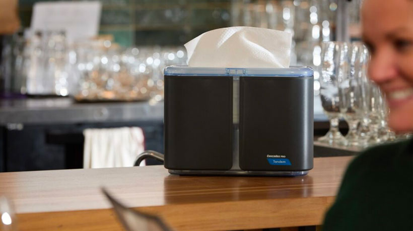 Distributrice pour comptoir pour essuie-mains de papier à plis multiples Cascades PRO Tandem® sur un comptoir de restaurant ou bar. Distributeur de papier